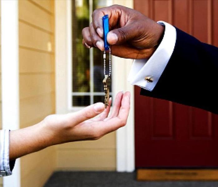 image of landlord handing over keys to a home to tenants