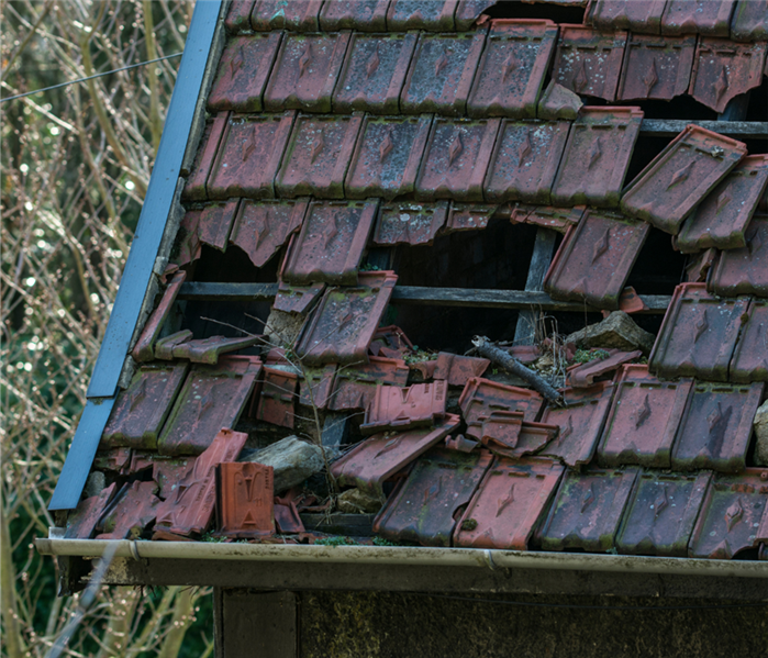 Picture is of a shaker shingle roof that has been ripped all apart due to high winds 