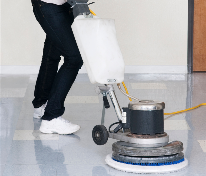 man cleaning floor with equipment